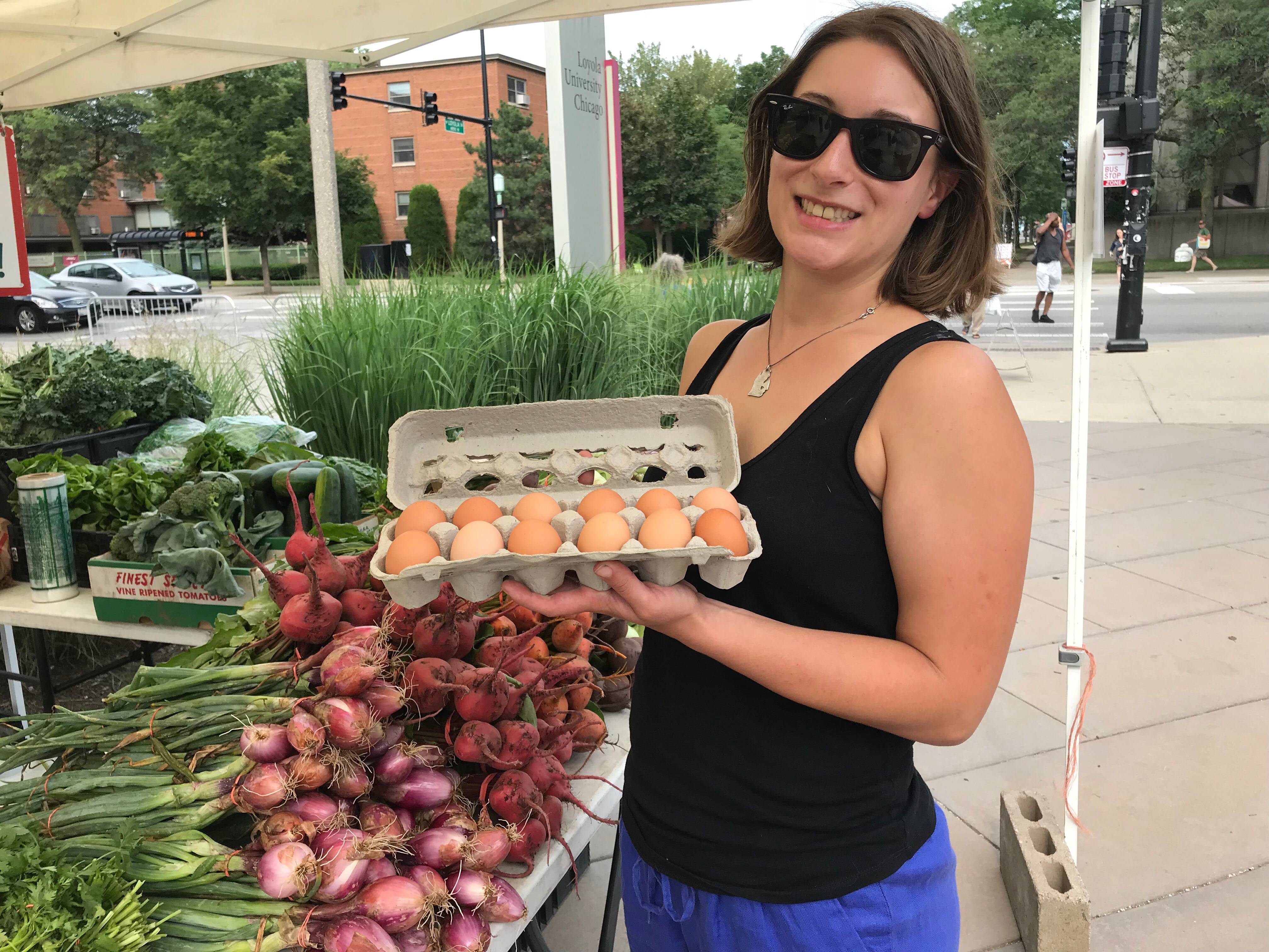 Chelsea Denault proudly shows off her purchase from the farmers market vegetable and egg vendor, John Patyk of Patyk Farms.